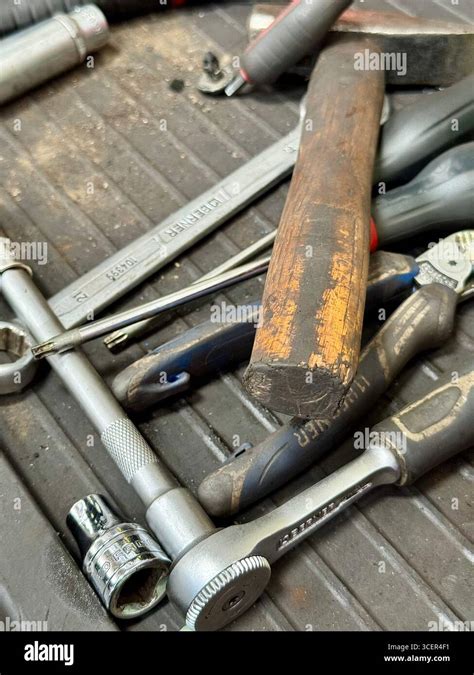 An assortment of basic car repair tools including screwdrivers, wrenches, and gloves