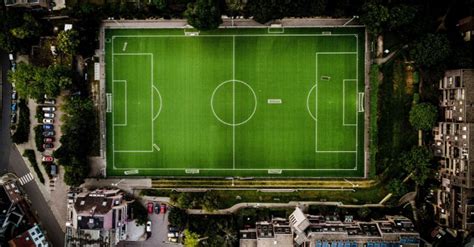 Tematinė nuotrauka: futbolo aikštė su žaidėjais, demonstruojančiais kamuolio varymą ir spurtą