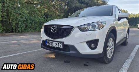 Mazda CX-5 visureigis važiuojantis užmiesčio keliu