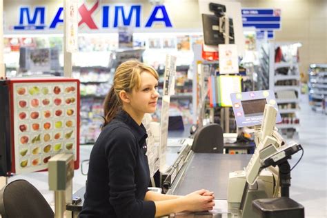 Tematinė nuotrauka: prekybos centro kasininkė, dirbanti su klientais ir kraunanti prekes