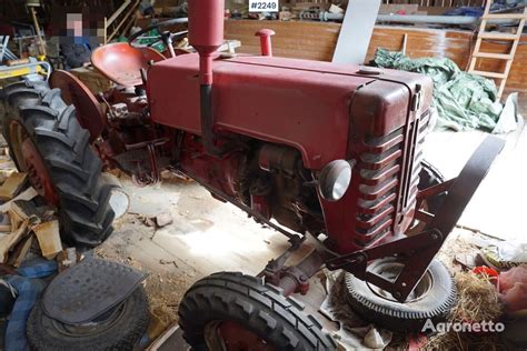 Senas International Harvester traktorius su darbiniu velenu dirba lauke