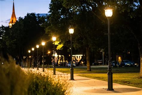 Senas gatvės žibintas naktį su aplink jį šviečiančiomis žvaigždėmis