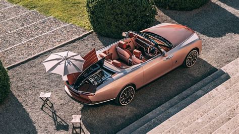 Rolls-Royce Boat Tail su atidaryta bagažine, demonstruojančia šampano rinkinį