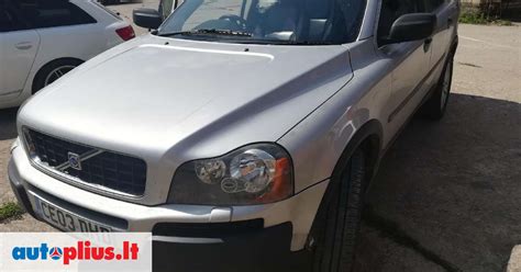 Volvo XC90 priekinė dalis, stovinti prie modernaus namo