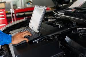 Mechanikas atlieka automobilio diagnostiką su kompiuteriu