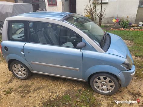Keturratis mikroautomobilis (pvz. Aixam arba Ligier) važiuojantis miesto gatve