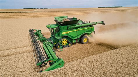 John Deere kombainas dirbantis lauke, nuimantis derlių