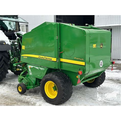 John Deere presas rulonuojantis šieną ar šiaudus lauke