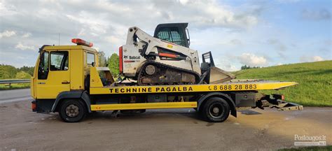 Teminė nuotrauka su automobilio gedimu kelyje ir atvykstančia technine pagalba