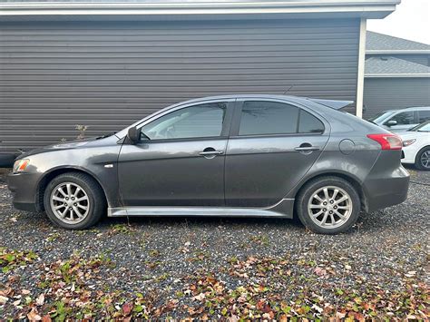 Mitsubishi Lancer važiuojantis užmiesčio keliu