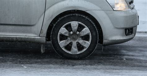 Teminė nuotrauka su automobilio padangomis ant šlapios ar apsnigtos kelio dangos