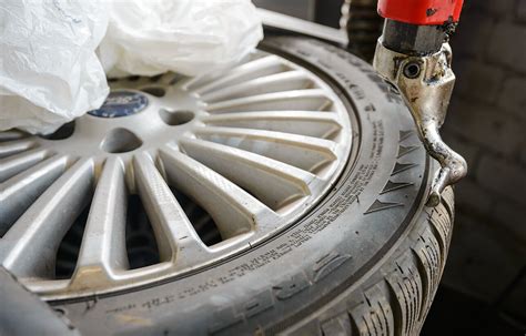 Teminė nuotrauka: žmogus valantis automobilio ratlankius specializuota priemone