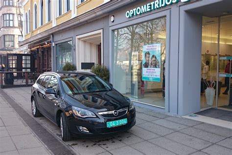 Ambasados automobilis su diplomatiniais numeriais, stovintis prie ambasados pastato