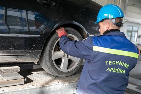 profesionalus autoservisas su meistrais, atliekančiais automobilio techninę apžiūrą