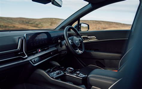Kia Sportage interjero nuotrauka su dideliais ekranais ir patogiu salonu
