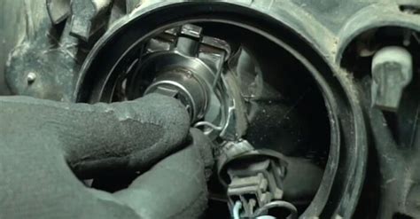 Detalė, rodanti priekinio žibinto lemputės fiksavimo spaustuką.