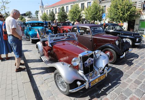 Teminė nuotrauka su istoriniais automobiliais, pavyzdžiui, senoviniu automobiliu važiuojančiu kaimo keliu Lietuvoje