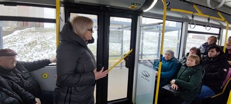 Teminė nuotrauka: autobuso salonas su keleiviais, žiūrinčiais pro langą