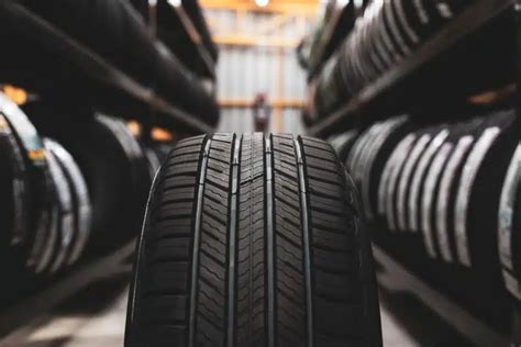 Teminė nuotrauka su naudotomis padangomis ir automobiliu kelyje