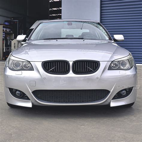 BMW E60 su grotelėmis ir emblema, priekinis vaizdas