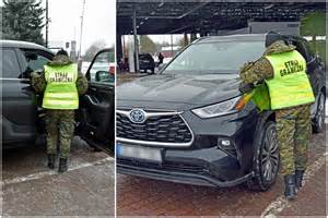 Autoserviso interjeras su specialistais, dirbančiais prie automobilio vairo sistemos