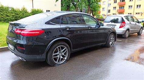 Tematinė nuotrauka: neeksploatuojamas automobilis su išleistomis padangomis ir aprūdijusiu kėbulu daugiabučio kieme