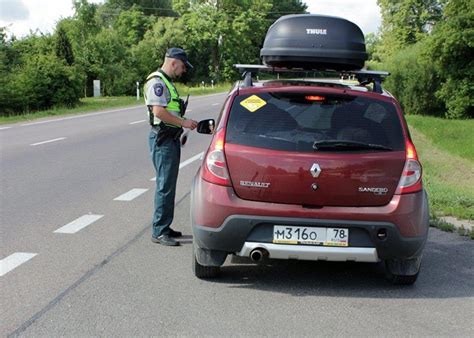 Teminė nuotrauka su automobilio valstybiniais numeriais ir Lietuvos kelio ženklu