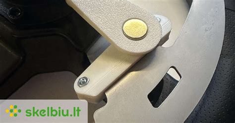 Vaizdas su vairo mentelėmis, skirtomis pavarų perjungimui, ir jų žymėjimais (+ ir -).