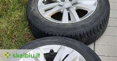 Teminis automobilis su žieminėmis padangomis ant apsnigtų kelių