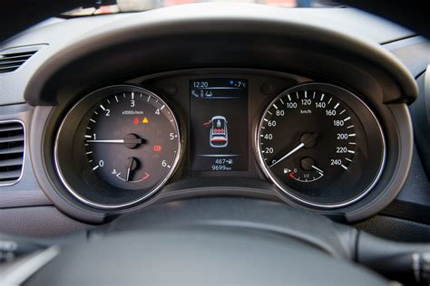 Technikas, dirbantis su automobilio prietaisų skydeliu ir spidometru
