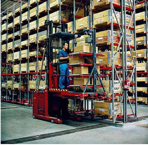 Teminė fotografija: sandėlio darbuotojas, vairuojantis elektrinį krautuvą moderniame logistikos centre