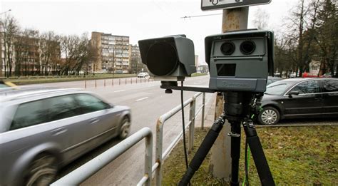 Teminė nuotrauka su greičio matuokliu ir policijos automobiliu
