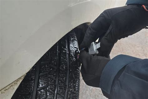foto: meistras tikrina padangų slėgį ir protektoriaus būklę servise