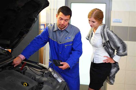 Serviso darbuotojai aptaria automobilio remontą