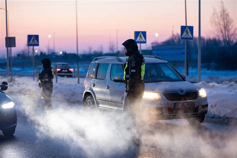 Nuotrauka, vaizduojanti policijos automobilį prie mokyklos arba policijos pareigūnus, bendraujančius su mokyklos personalu