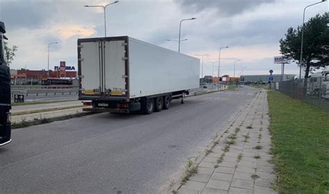 Vilkiko priekabos užpakalinė dalis su užlipančiais migrantais eismo spūstyje