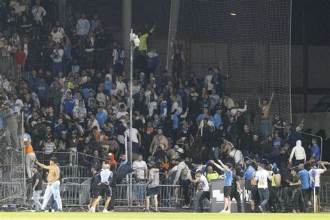 Futbolo sirgaliai dideliame stadione su dūminiais deglais ir vėliavomis