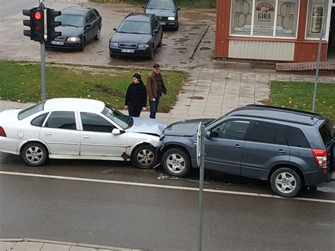 Dvieju automobilių susidūrimas Rygos ir Taikos gatvių sankryžoje - apgadinti automobiliai ir stulpas