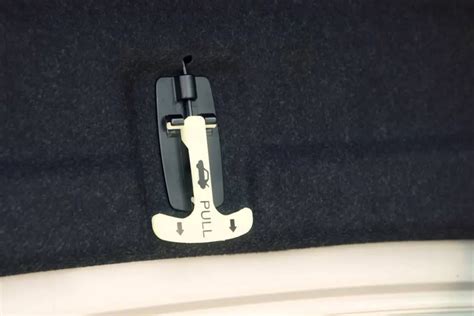 Schema: Avarinis bagažinės atidarymo mechanizmas iš automobilio vidaus