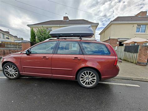Volvo V50 automobilio šoninis vaizdas parke, akcentuojant universalumo dizainą