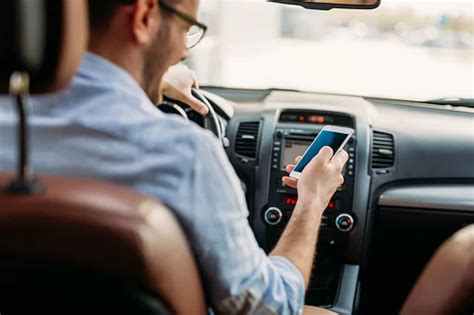 Tematinė nuotrauka: žmogus, besitransliuojantis su telefonu automobilyje