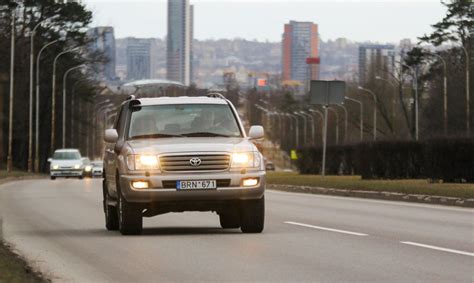 Automobilis, važiuojantis slidžiu keliu, su įjungtais rūko žibintais