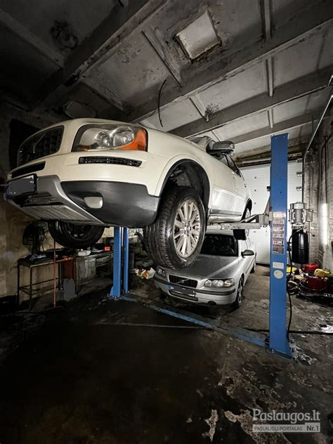 Nuotrauka, vaizduojanti autoserviso meistrus, atliekančius automobilio remonto darbus