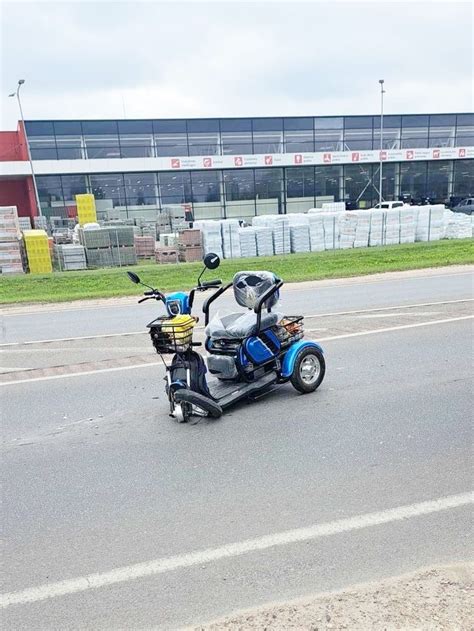 Tematinė nuotrauka: vyresnio amžiaus žmogus važiuojantis elektriniu triračiu motoroleriu