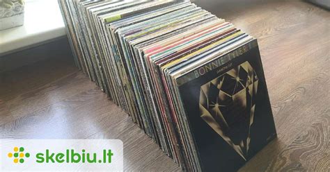 Tematinė nuotrauka: žmogus, besiklausantis vinilo plokštelės su įjungtu patefonu