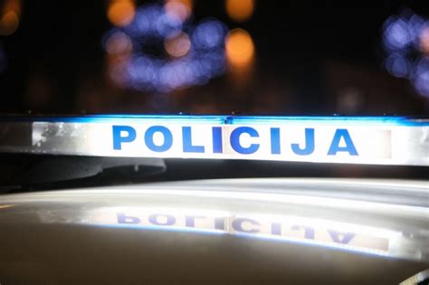 Teminė nuotrauka, vaizduojanti policijos patrulį naktį prie automobilio