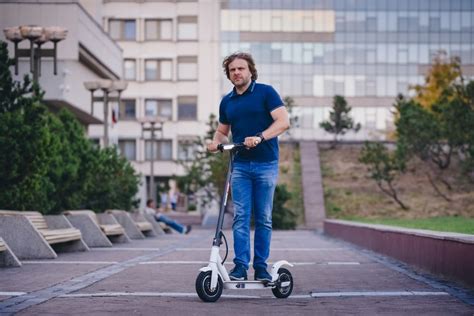 Teminė nuotrauka: žmogus, važiuojantis elektriniu paspirtuku mieste